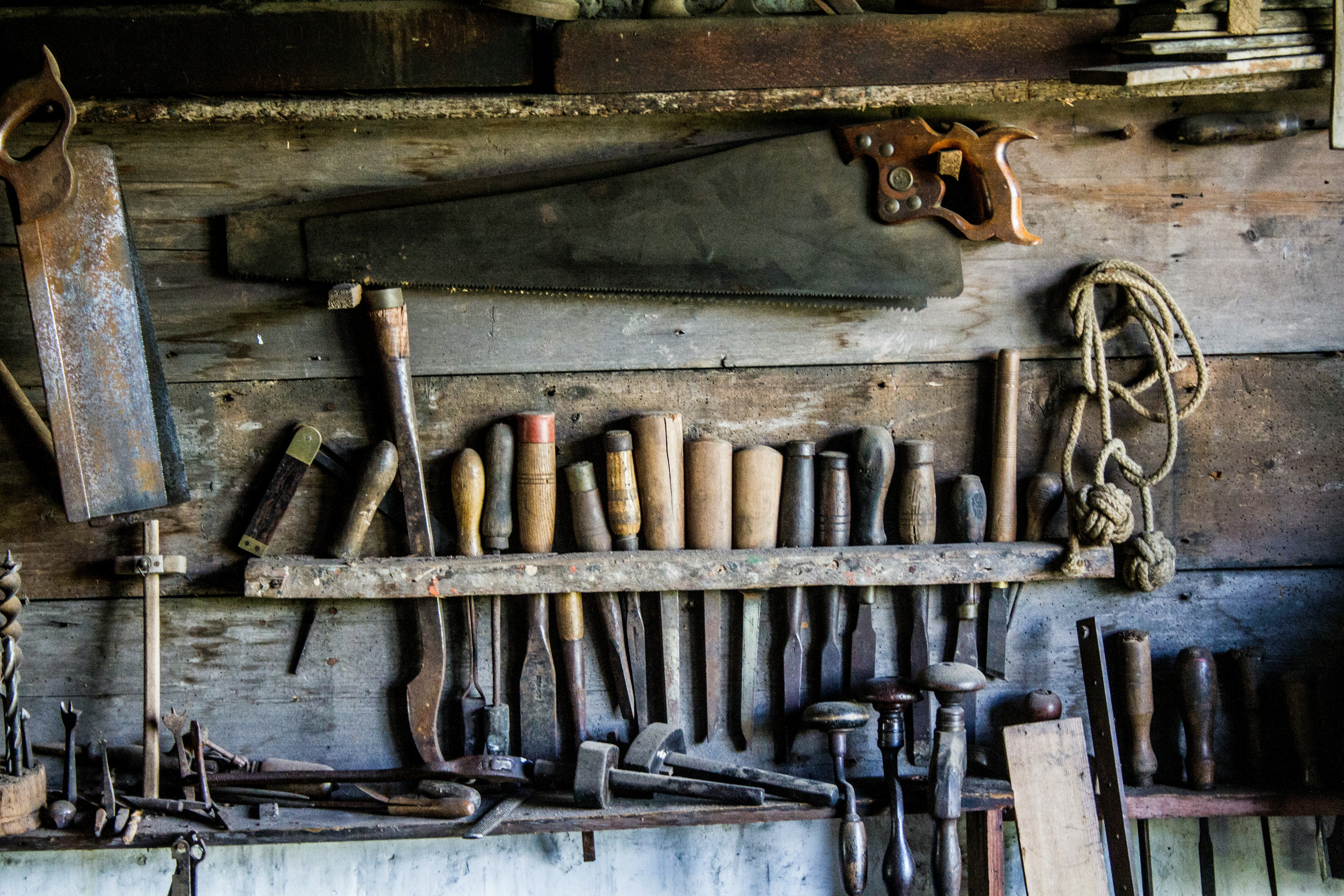 A wall with an array of antique tools hanging in place
