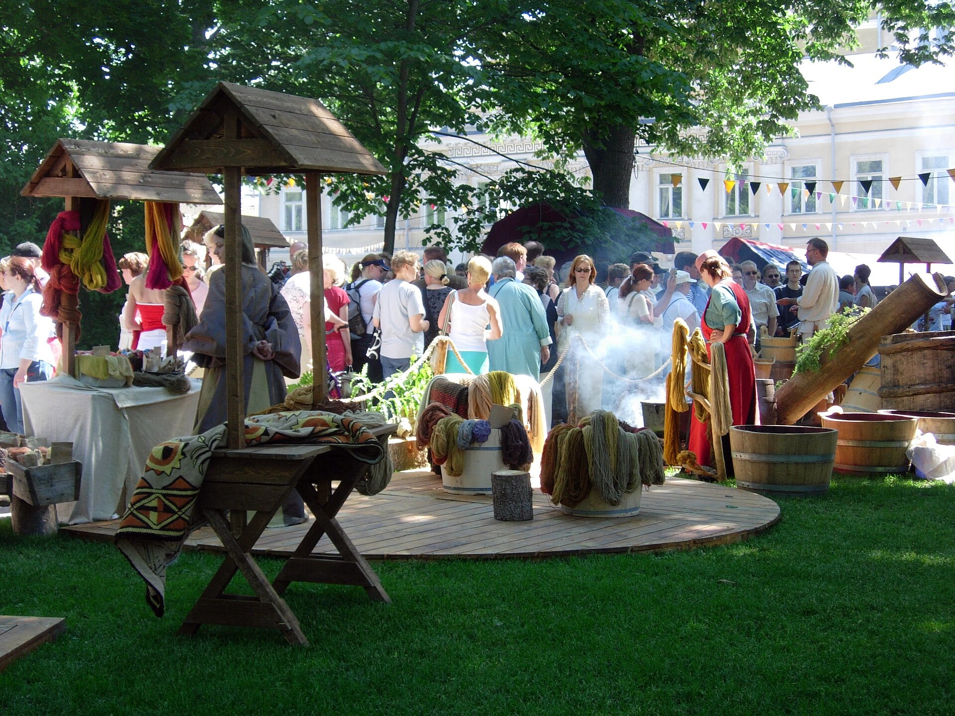 A crowd bustles through a ren fair market